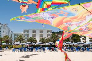 un aquilone che vola su una spiaggia con sedie e ombrelloni di Hotel Parco Delle Rose a Silvi Marina
