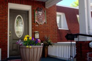 a porch with a pot of flowers in front of a house at Maria's Garden & Inn in Berkeley Springs