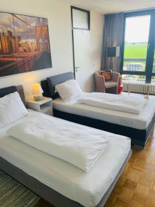 a hotel room with two beds and a window at Messe Apartment Köln West in Cologne