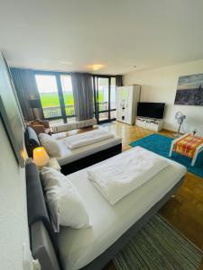a bedroom with two beds and a living room at Messe Apartment Köln West in Cologne