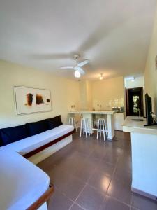 a living room with a couch and a kitchen at Hotel Canto do Rio Maresias in Maresias