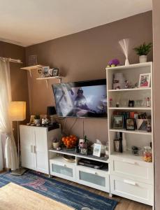 een woonkamer met een tv en een witte boekenplank bij apartment IVA in Supetarska Draga