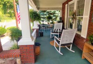 a patio area with chairs, tables and umbrellas at Maria's Garden & Inn in Berkeley Springs