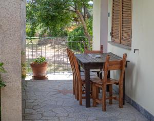 un tavolo e sedie di legno su un patio di Turismo Rurale CUDACCIOLU a Arzachena Altre 26 foto