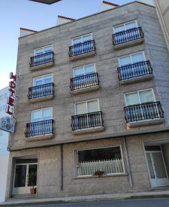 un edificio con balcones en un lateral en Hotel Grove, en O Grove