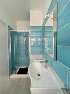 W łazience znajduje się biała umywalka i prysznic. w obiekcie Donnabella house w Agropoli