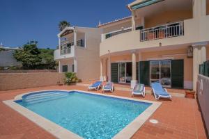 uma villa com piscina em frente a uma casa em Villa Acacias 18, Brisa do Mar na Praia da Luz