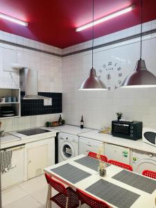 cocina con mesa y reloj en la pared en Zentric Hostel, en León