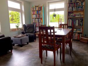 a living room with a table and chairs and bookshelves at Lowlander BnB in Heemskerk