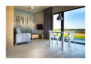 a living room with a table and chairs and a couch at Hotel Roś in Pisz