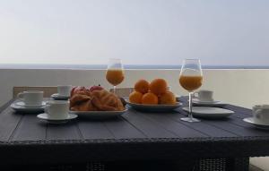 einen Tisch mit einem Obstteller und zwei Gläsern Wein in der Unterkunft Vivienda Tauro in Puerto del Carmen