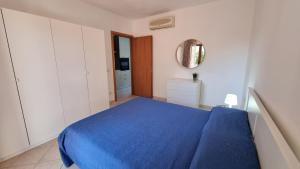 1 dormitorio con 1 cama azul en una habitación blanca en My Place in Sardinia, en Olbia