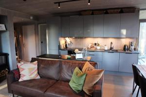 a living room with a couch and a kitchen at Cozy Apartment by the slopes in Kvitfjell Vest in Favang