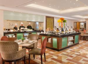 a restaurant with two chefs in the kitchen and a buffet at Richmonde Hotel Ortigas in Manila