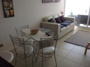 uma sala de estar com uma mesa e cadeiras e um sofá em Departamento Playa La Herradura em Coquimbo