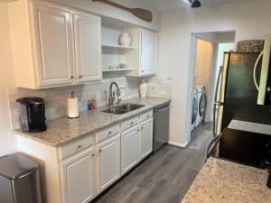 a kitchen with white cabinets and a sink at St Augustine Beach Condo 3/5 Min Walk Beach/Cafes in St. Augustine