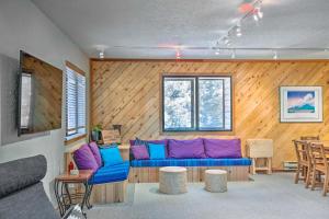 a living room with a blue couch and wooden walls at Roomy Angel Fire Home with Hot Tub, Sunroom and Views! in Angel Fire