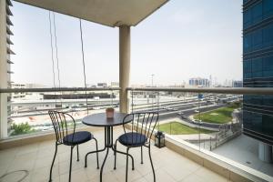 a table and chairs on a balcony with a view of a highway at HiGuests - Deiras Lucky Find, 5-min to the Airport in Dubai