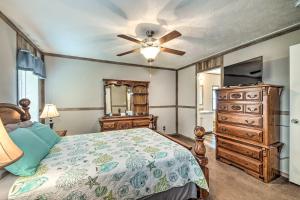 um quarto com uma cama, uma cómoda e uma ventoinha de tecto em Cozy Hardin Retreat with Lake Kentucky View! em Aurora