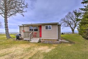 una casa pequeña con una puerta roja en un patio en Peace and Premier Fishing on Bay of Green Bay!, en Oconto