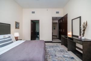 una camera da letto con un letto, un comò e uno specchio di HiGuests - Deiras Lucky Find, 5-min to the Airport a Dubai