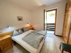 a bedroom with a bed and a large window at Appartamenti Vacanze Lagolo in Lagolo di Calavino