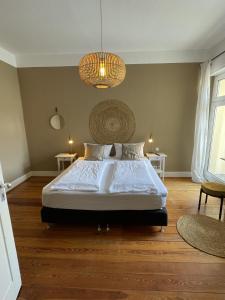 a bedroom with a large bed and a chandelier at AUERSTEIN-Hotels auerstein & auerstein-mono in Heidelberg