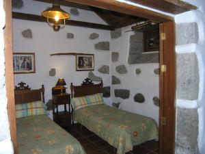 1 dormitorio con 2 camas en una habitación de piedra en La Casita de Andres 1 en Agüimes