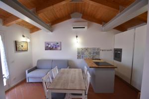 a kitchen and dining room with a table and a couch at Complesso La Foce - Clima, parcheggi, spazi esterni privati in Marina di Campo