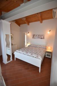 a bedroom with a white bed and a wooden ceiling at Complesso La Foce - Clima, parcheggi, spazi esterni privati in Marina di Campo