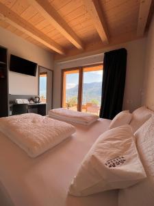 sypialnia z 2 łóżkami i dużym oknem w obiekcie Agriturismo Margone w Trydencie