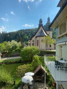 a balcony of a house with an umbrella at Kleines Haus Silberdistel in Todtmoos