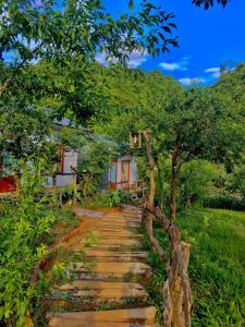 un sentiero in pietra di fronte a una casa di Plum Hill - Moc Chau a Mộc Châu