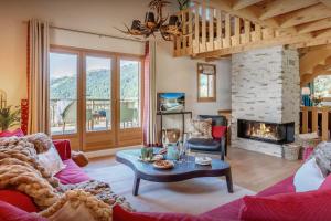 a living room with a couch and a fireplace at Chalet Joux Verte - OVO Network in Les Gets