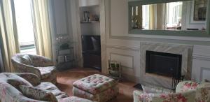 sala de estar con chimenea, sillas y espejo en La Casa sul Colle, en Spoleto