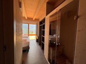a room with two beds and a glass door with a window at Agriturismo Margone in Trento