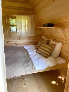 Cama en una cabaña de madera con ventana en Egn Boutique Hotel, en Stege