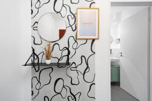 corridoio con specchio e parete con carta da parati in bianco e nero di Modernes Wohnen in Düren a Düren - Eifel