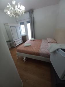 1 dormitorio con cama y lámpara de araña en Il Sole, en Rímini