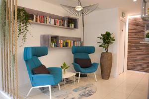 twee blauwe stoelen en een tafel in een kamer bij Hotel Renania in Bibione