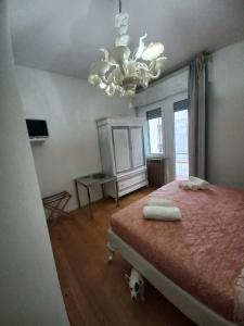 Un dormitorio con una cama grande y una lámpara de araña. en Il Sole, en Rímini