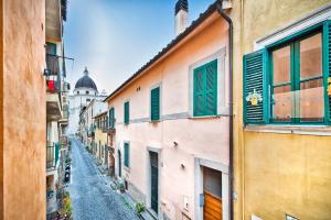 un callejón entre dos edificios con persianas verdes en Il Raduno en Castel Gandolfo