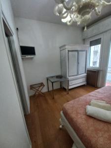 - une chambre avec un lit, une table et un lustre dans l'établissement Il Sole, à Rimini