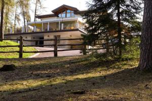 a house with a fence in front of it at hotel Parco Pineta in Cavareno