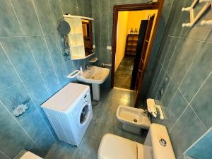 een badkamer met een wastafel, een toilet en een spiegel bij Bilocale Pf in Loano