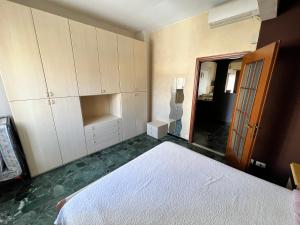 een slaapkamer met een wit bed en een spiegel bij Bilocale Pf in Loano