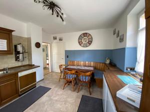 een keuken met een tafel en stoelen en een klok aan de muur bij Haus Silberdistel in Todtmoos