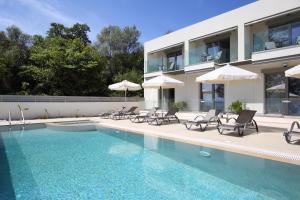 a house with a swimming pool with chairs and umbrellas at ALMYRA seafront residence in Lygia