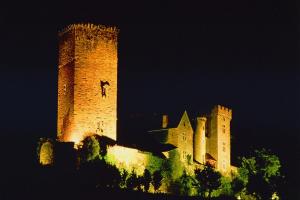 a large castle with a tower at night at Hotel du Touring in Saint-Céré