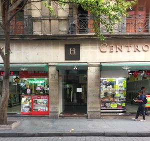 una mujer caminando por una tienda en una calle de la ciudad en Mexico City Hostel en Ciudad de México